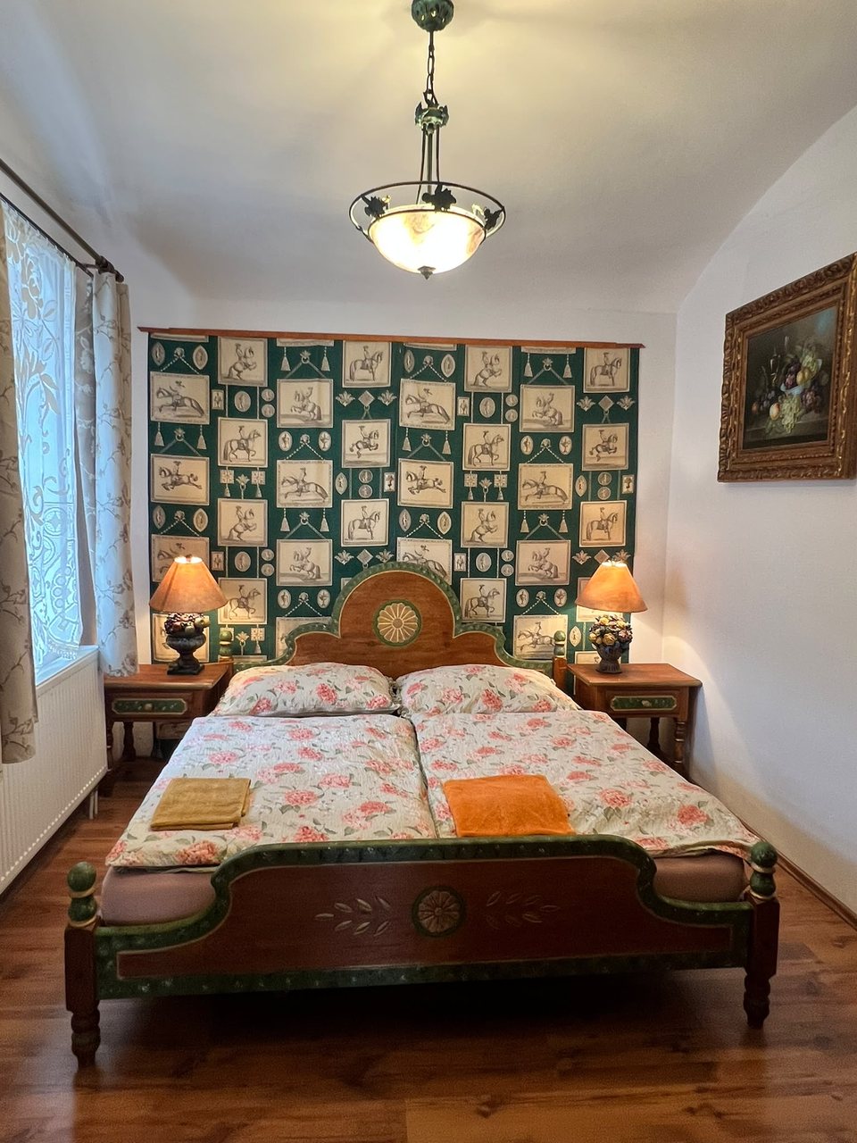 Ložnice se zelenou tapetou a malovanou postelí