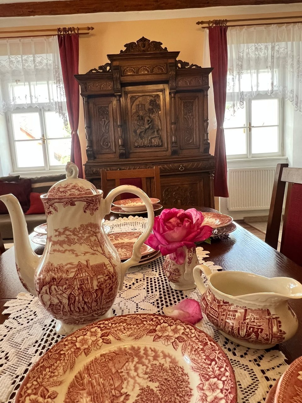 Stůl s porcelánem a vyřezávanou kredencí